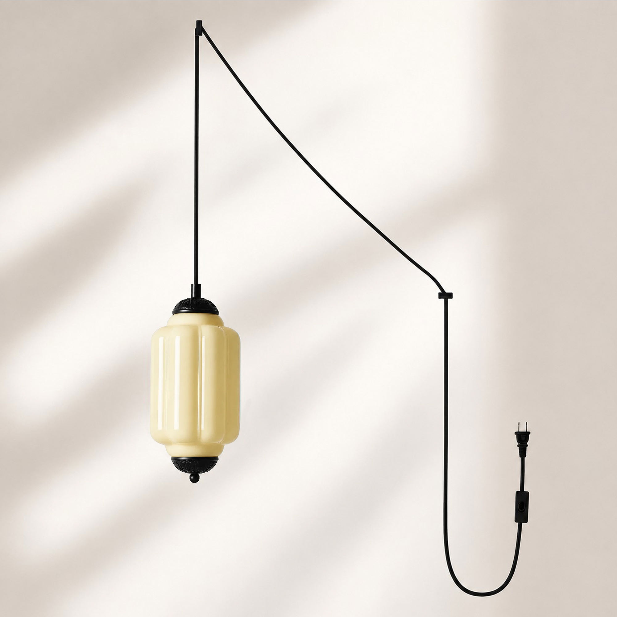 Lampadario a sospensione con finitura nera e paralume in vetro giallo.