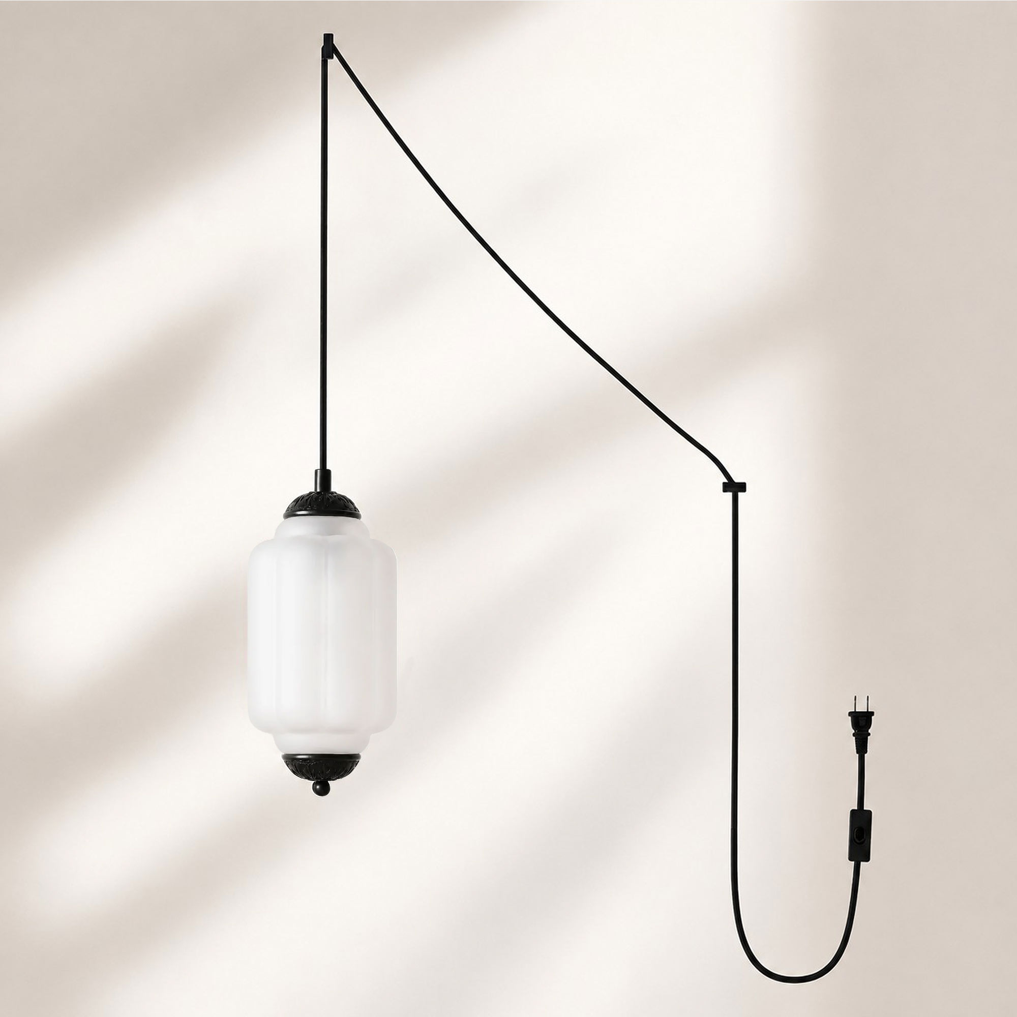 Lampadario a sospensione con finitura nera e paralume in vetro satinato.