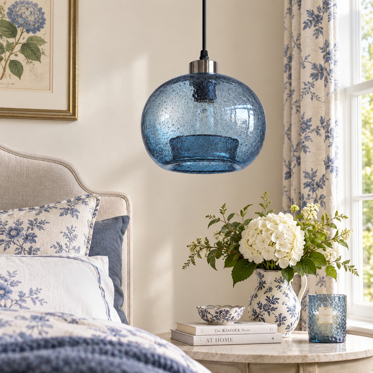 Suspension en verre texturé bleu au-dessus d'une table de chevet dans une chambre à motifs floraux