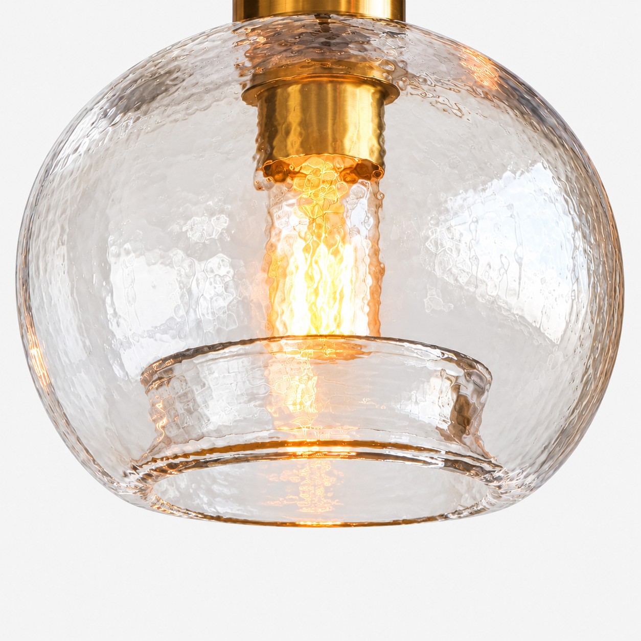 Ampoule à filament illuminée visible à travers un globe en verre texturé avec une base ouverte