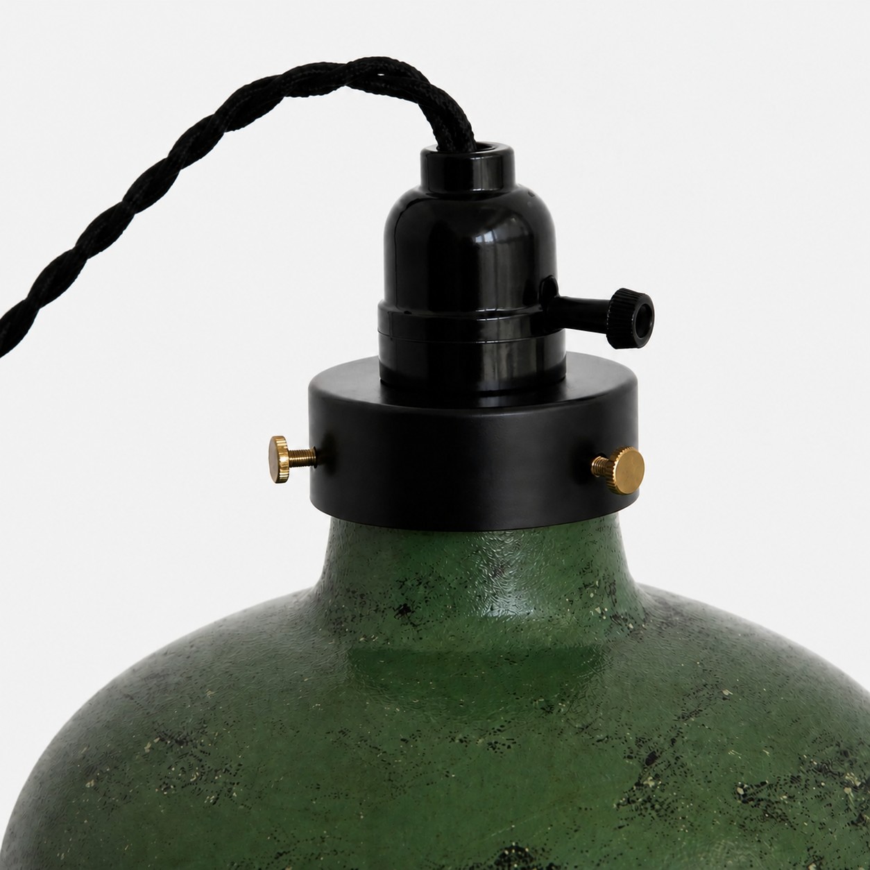 Close view of pendant socket, braided cord and distressed green metal finish