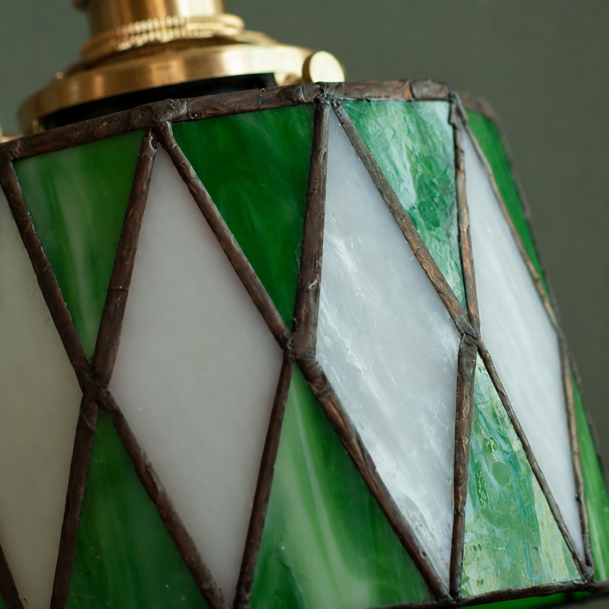 Luminária pendente de vitral verde sobre fundo branco