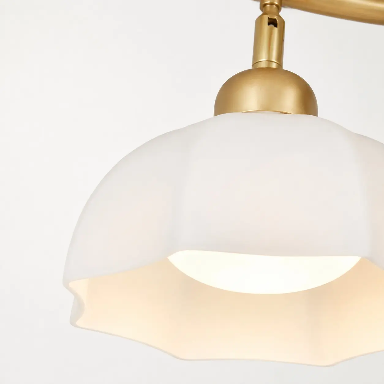 Detalj av vit glasskärm i form av en blommig skärm