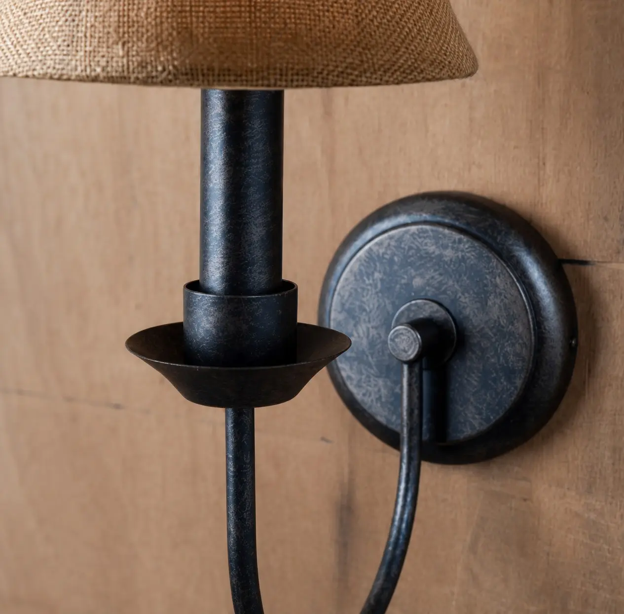 Close view of iron arm and round wall plate