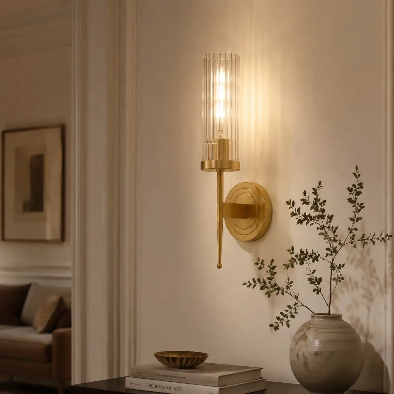 Vägglampa i mässing och glas med ett enda huvud i en elegant interiör