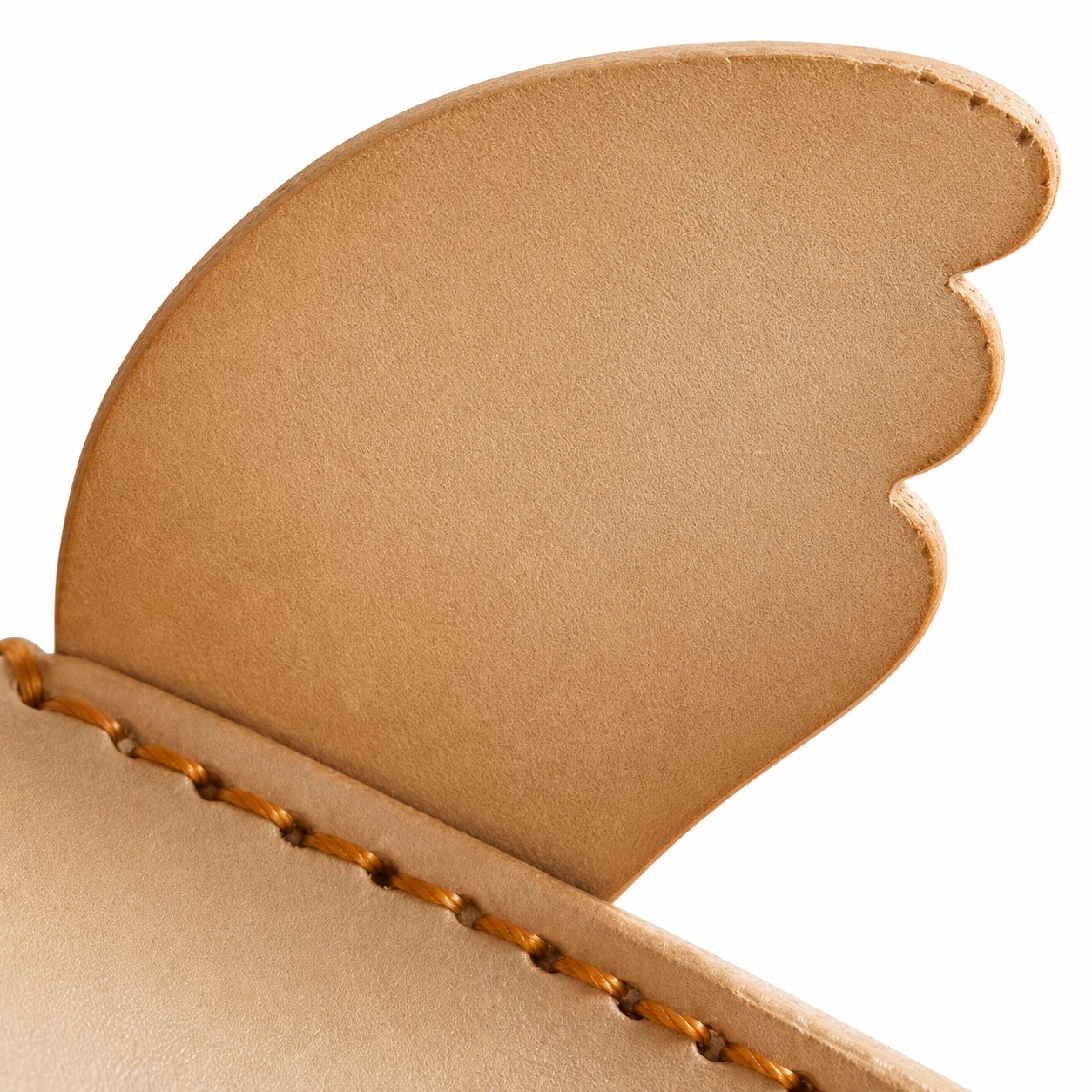 Pelle conciata al vegetale e dettagli di cucitura a mano.