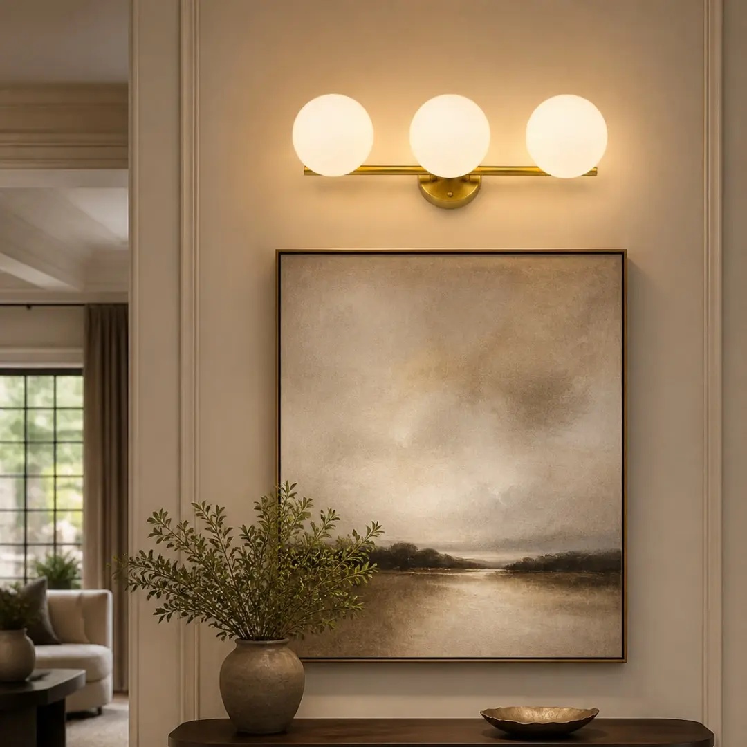 Three-light gold milk glass wall light above a console