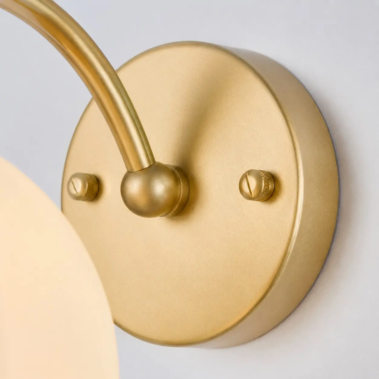 Gros plan sur la plaque murale et le bras de lampe incurvé