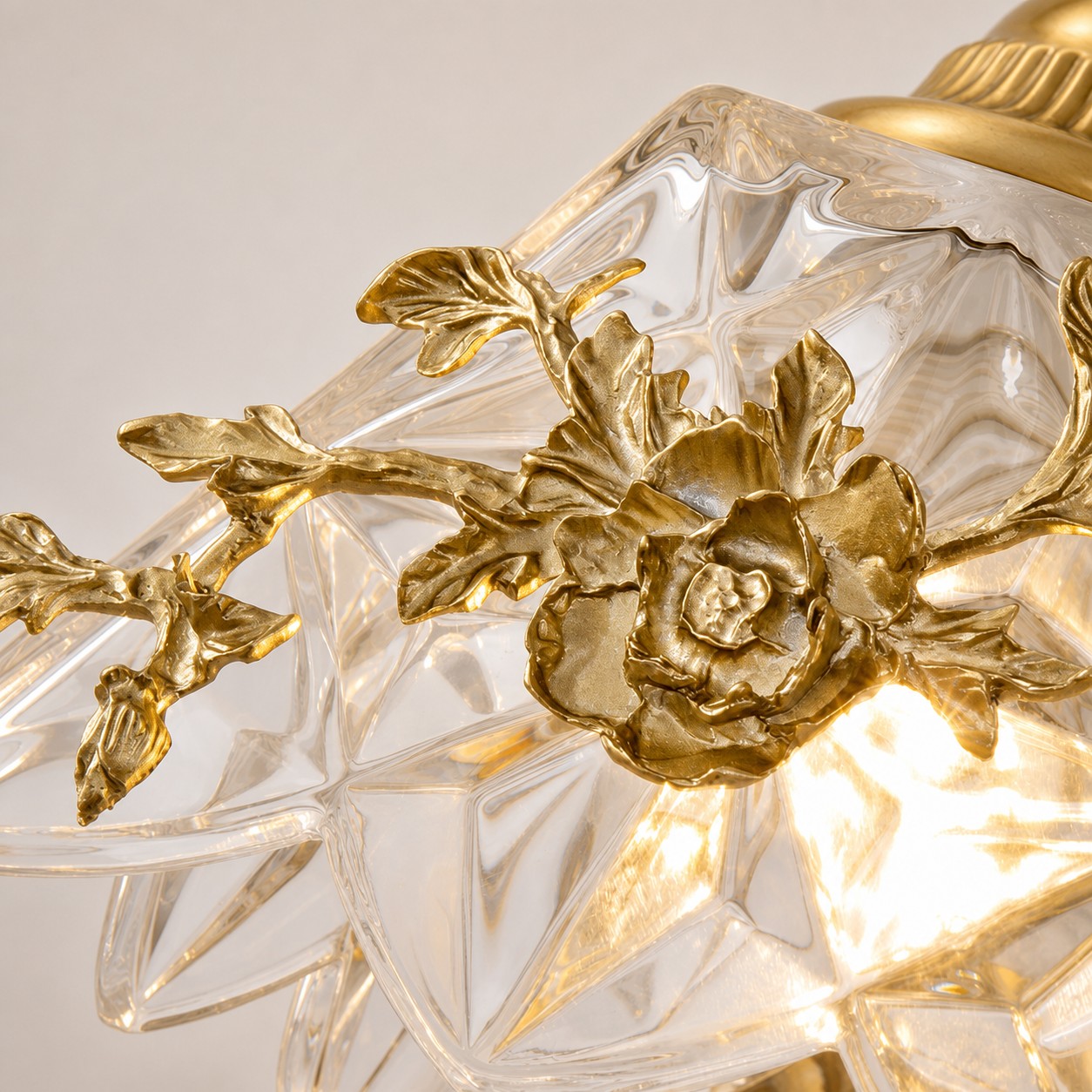 Detalhe em close-up da cúpula de vidro floral e da flor em tom de latão.