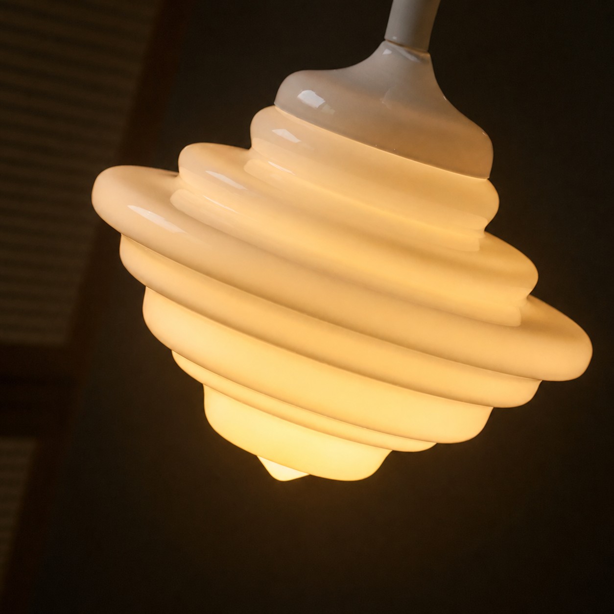 Vista de cerca de una lámpara colgante de cristal blanco iluminada