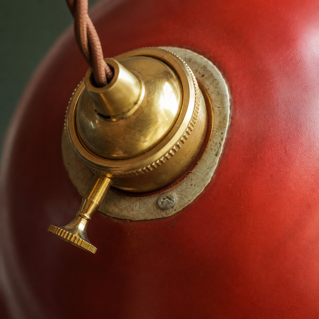Close view of the brass-toned fitting and ceramic shade surface