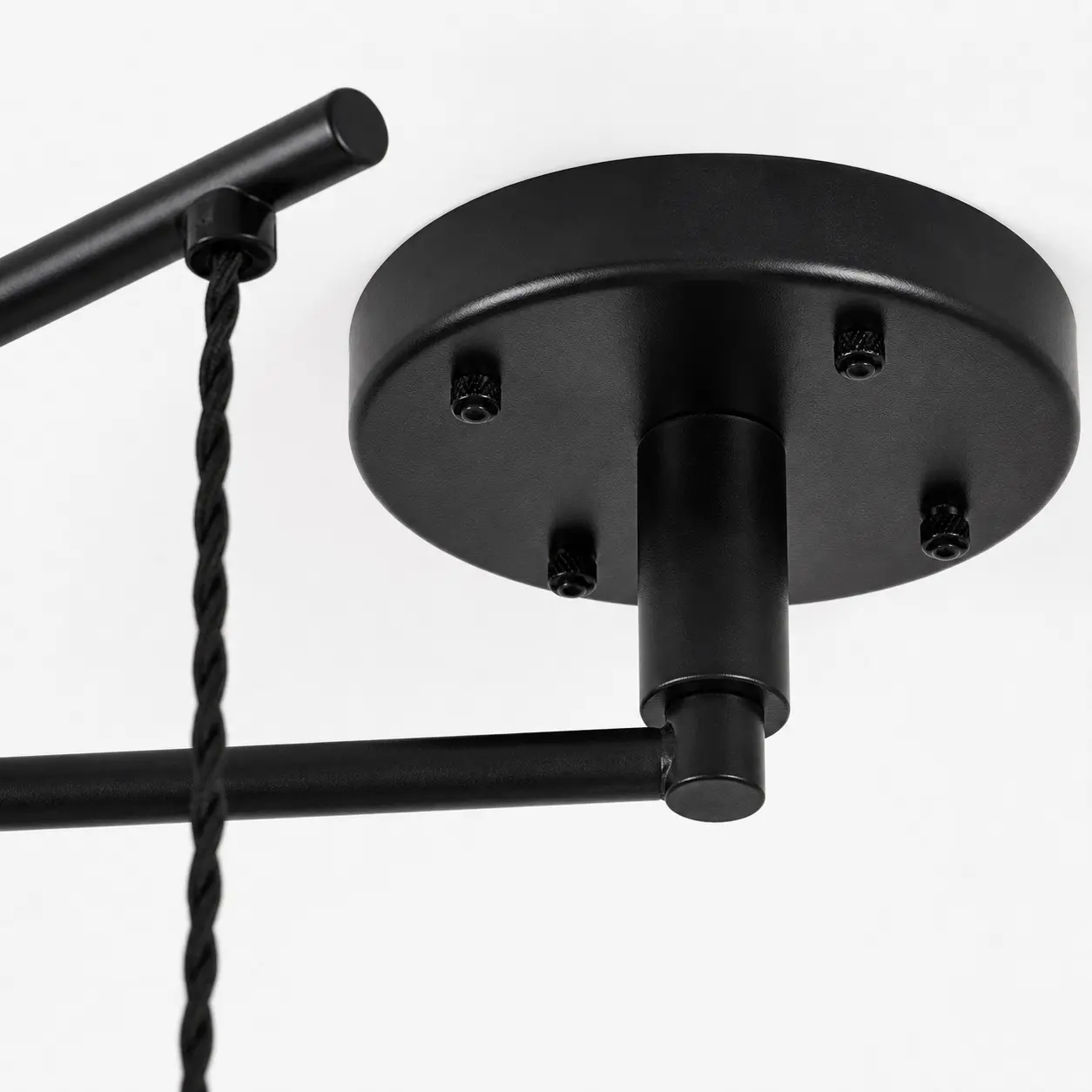 Détail de la rosace de plafond noire et du bras mobile