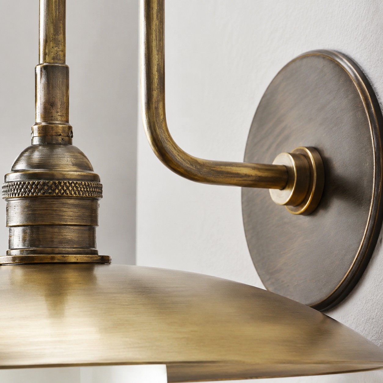 Detailed view of the Cantina lamp socket and curved antique brass arm