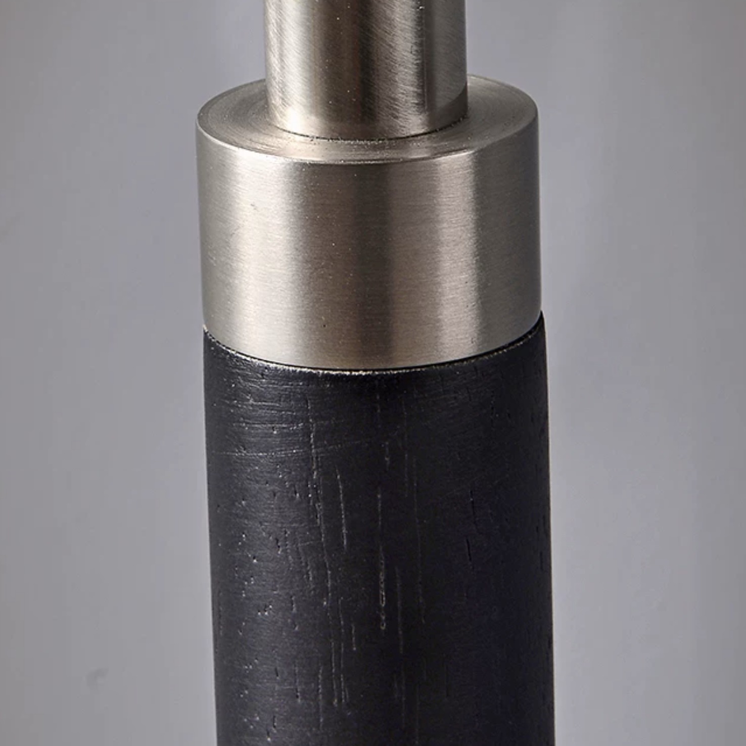 Black solid wood lamp stem with a brushed metal joint