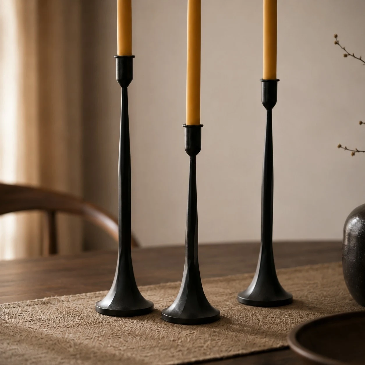 Three black iron candle holders in graduated heights