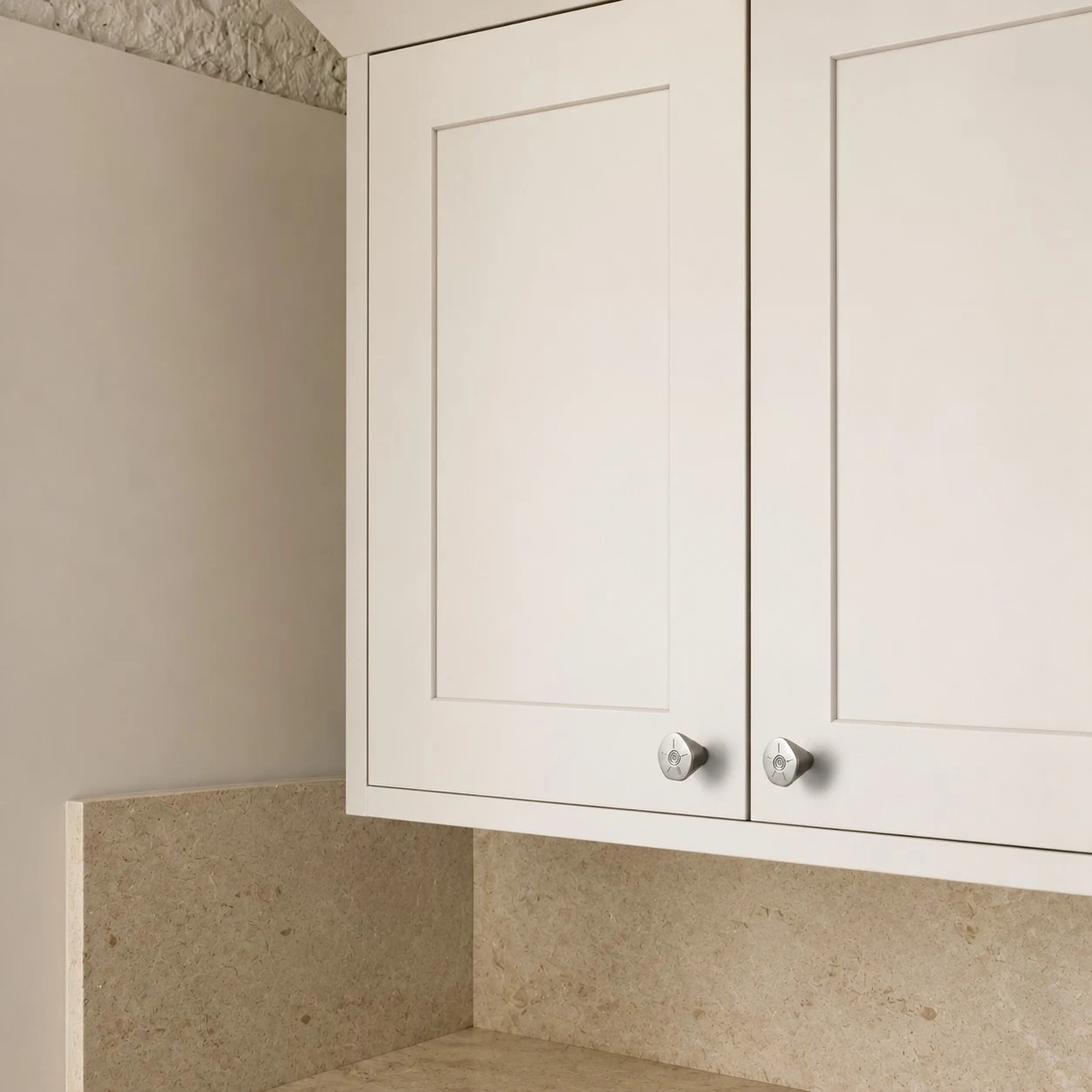 Titanium silver knobs installed on white cabinet doors