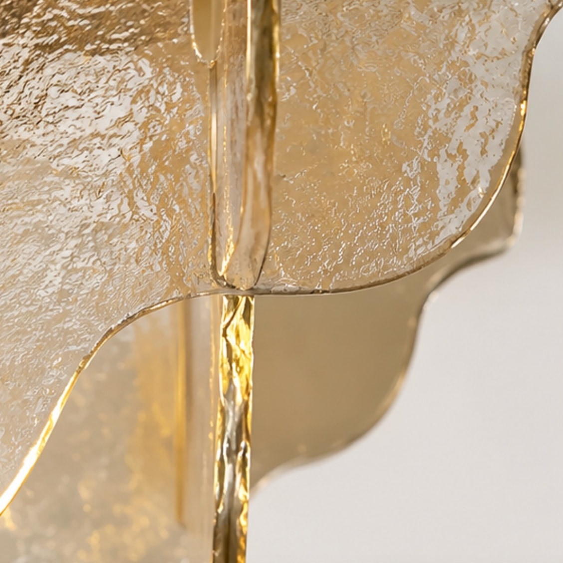 Nahaufnahme von strukturiertem bernsteinfarbenem Glas und Metallstiel