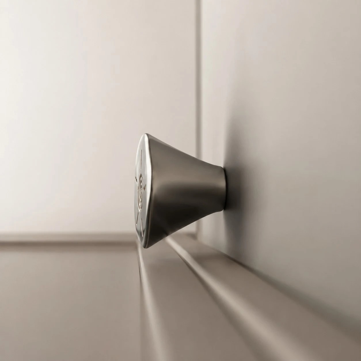 Side profile of titanium silver solid brass cabinet knob installed on cabinetry