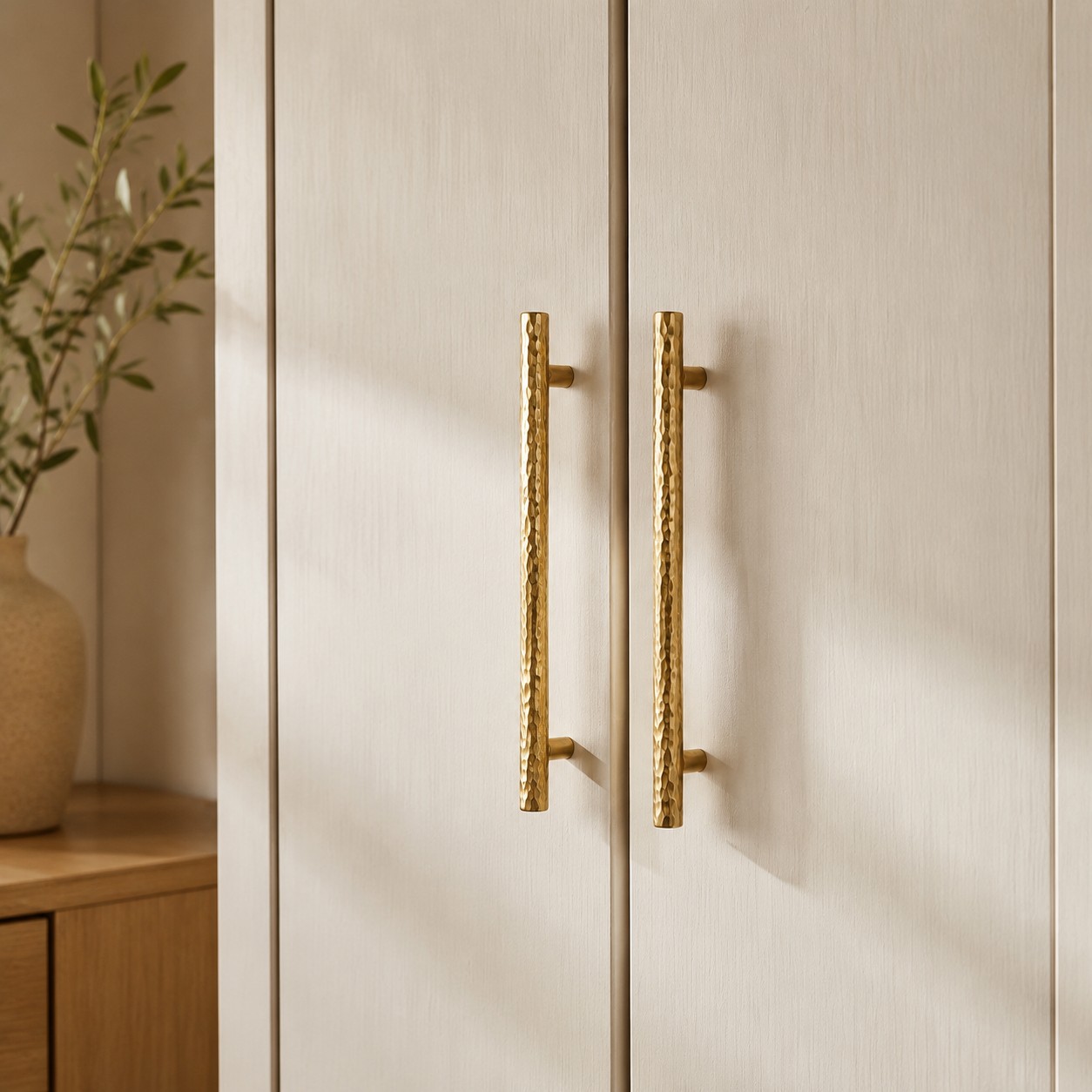 Natural Brass hammered bar pulls installed vertically on wardrobe doors