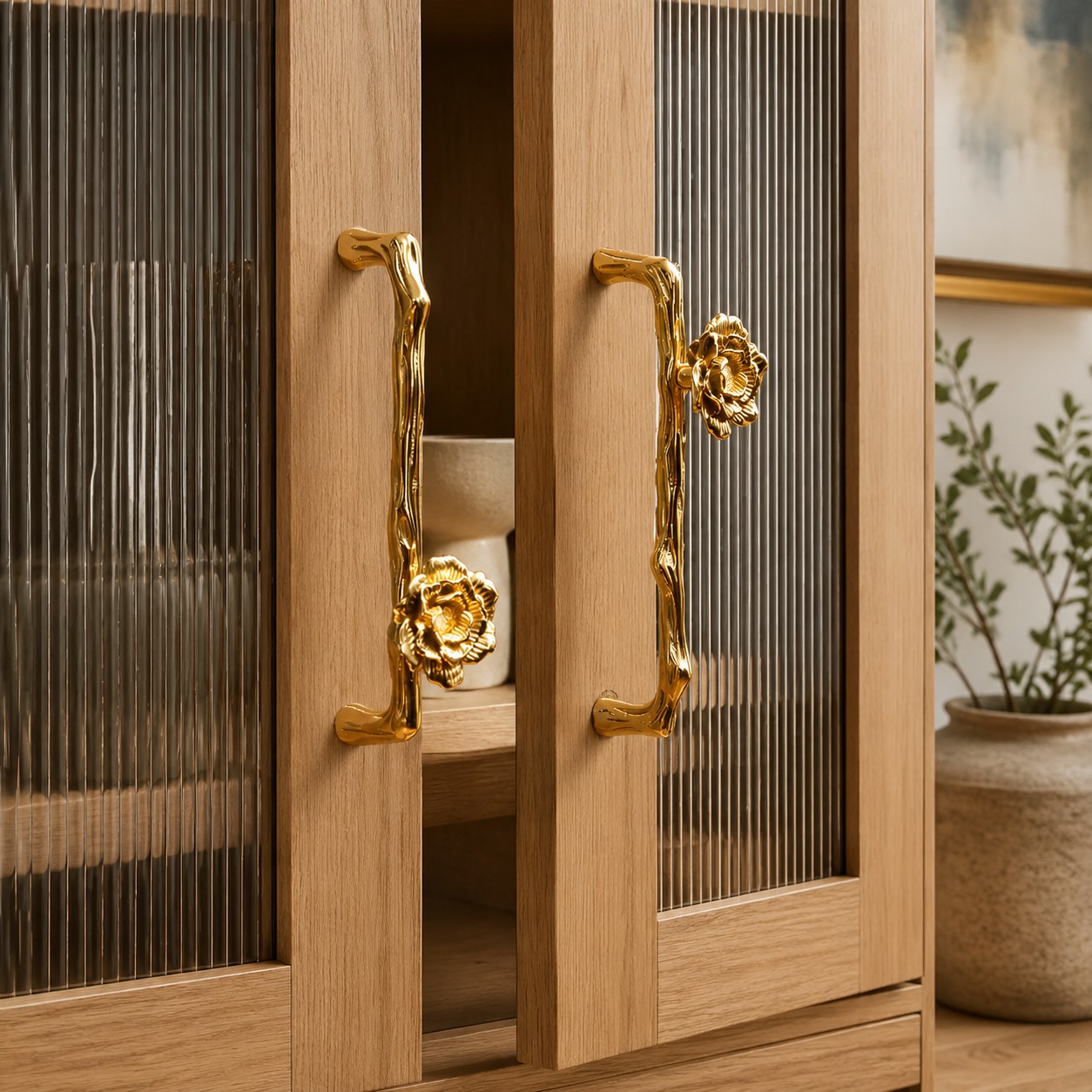 Flower and branch brass handles installed on a warm wood cabinet