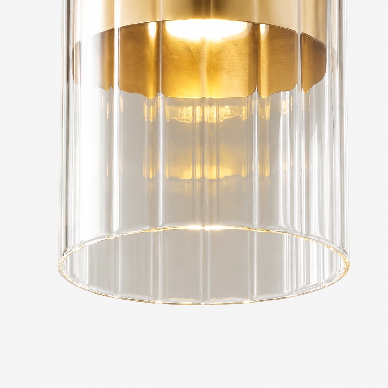 Close-up of ribbed clear glass shade on brass pendant light