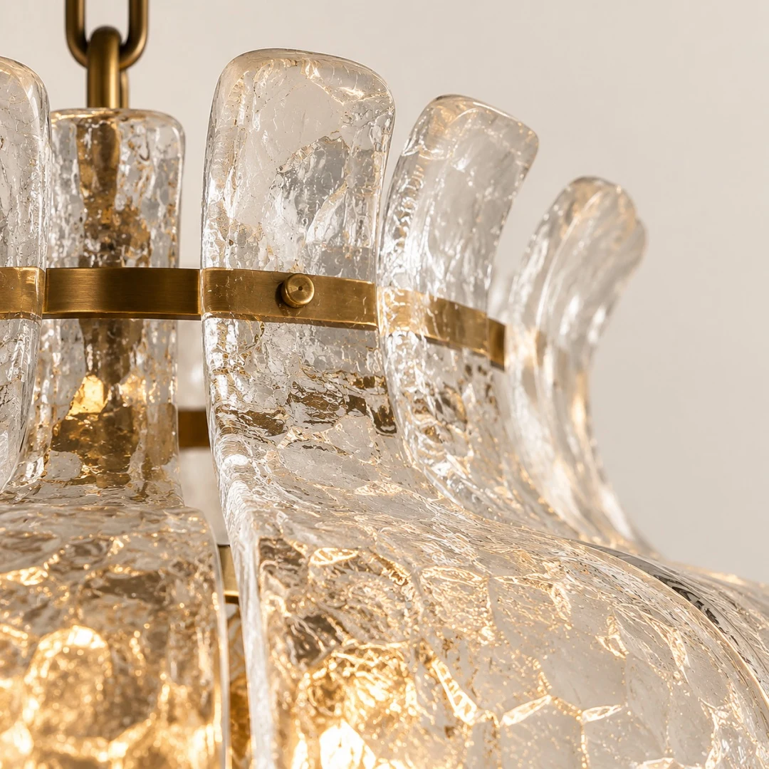 Layered clear glass shade around brass chandelier frame
