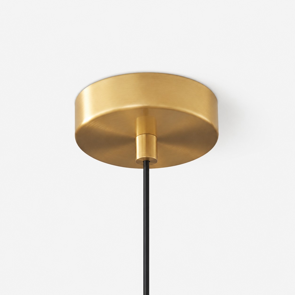 Close-up of round brass ceiling plate and black cable