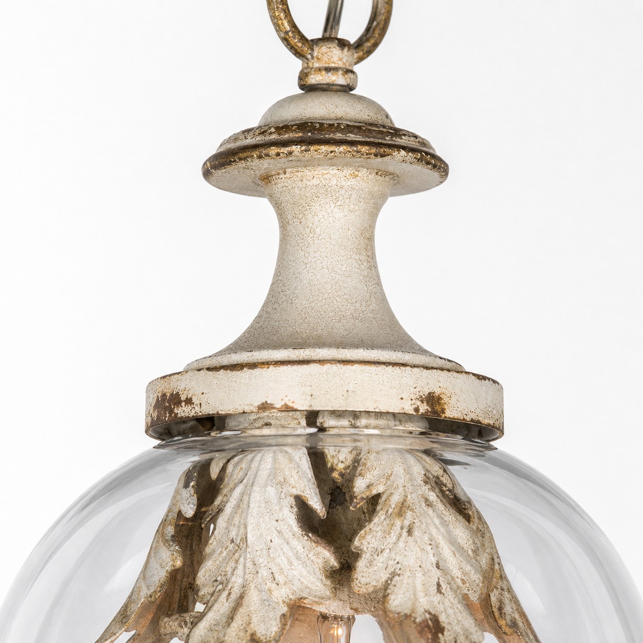 Close view of the metal connection and clear glass shade