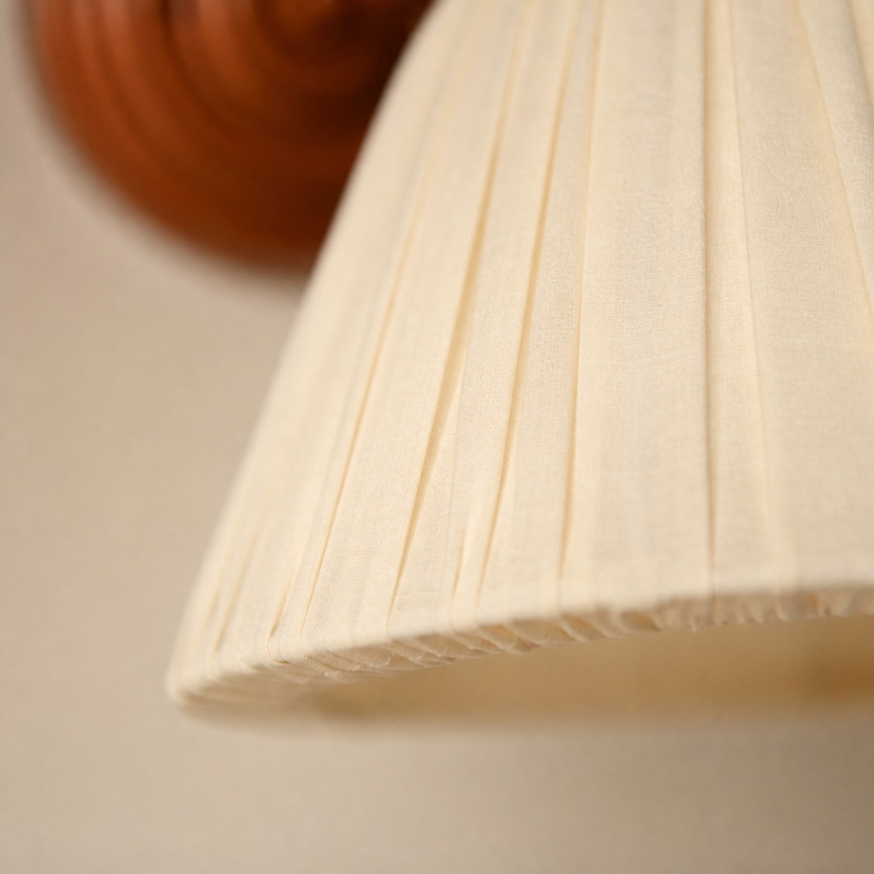 Pleated fabric shade with a soft cream tone.