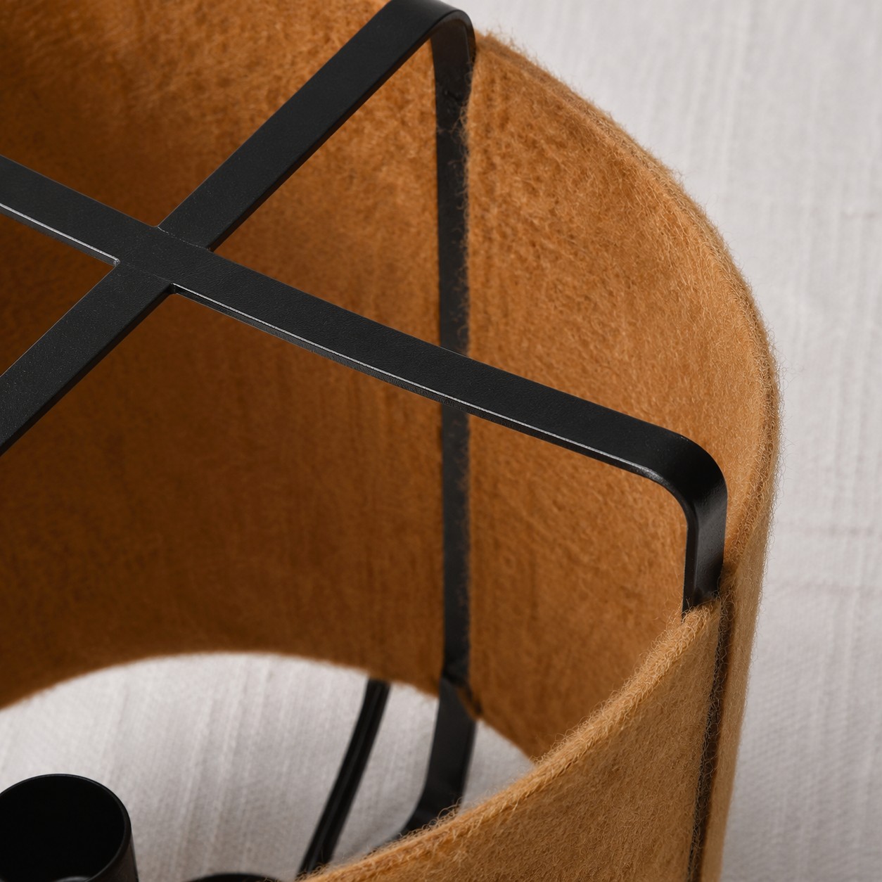 Close view of the black metal frame and coffee fabric shade