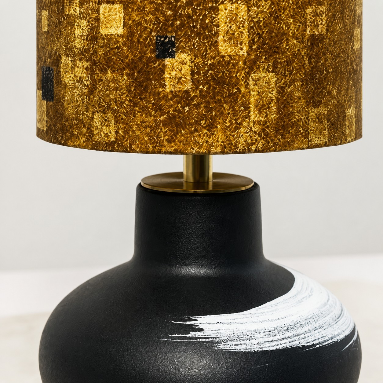 Close view of the ceramic lamp body and brass-toned stem