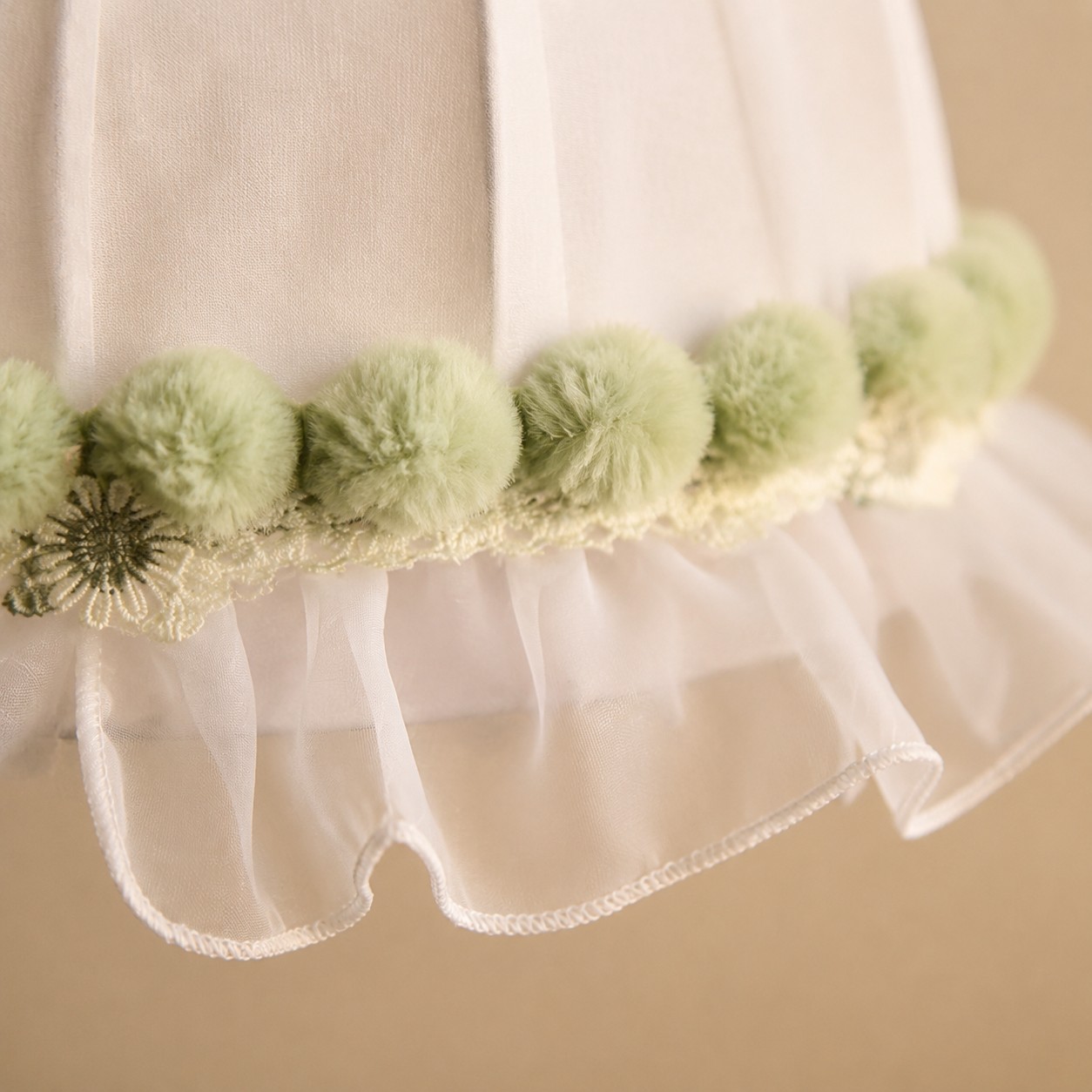 Soft green pom-pom and lace trim