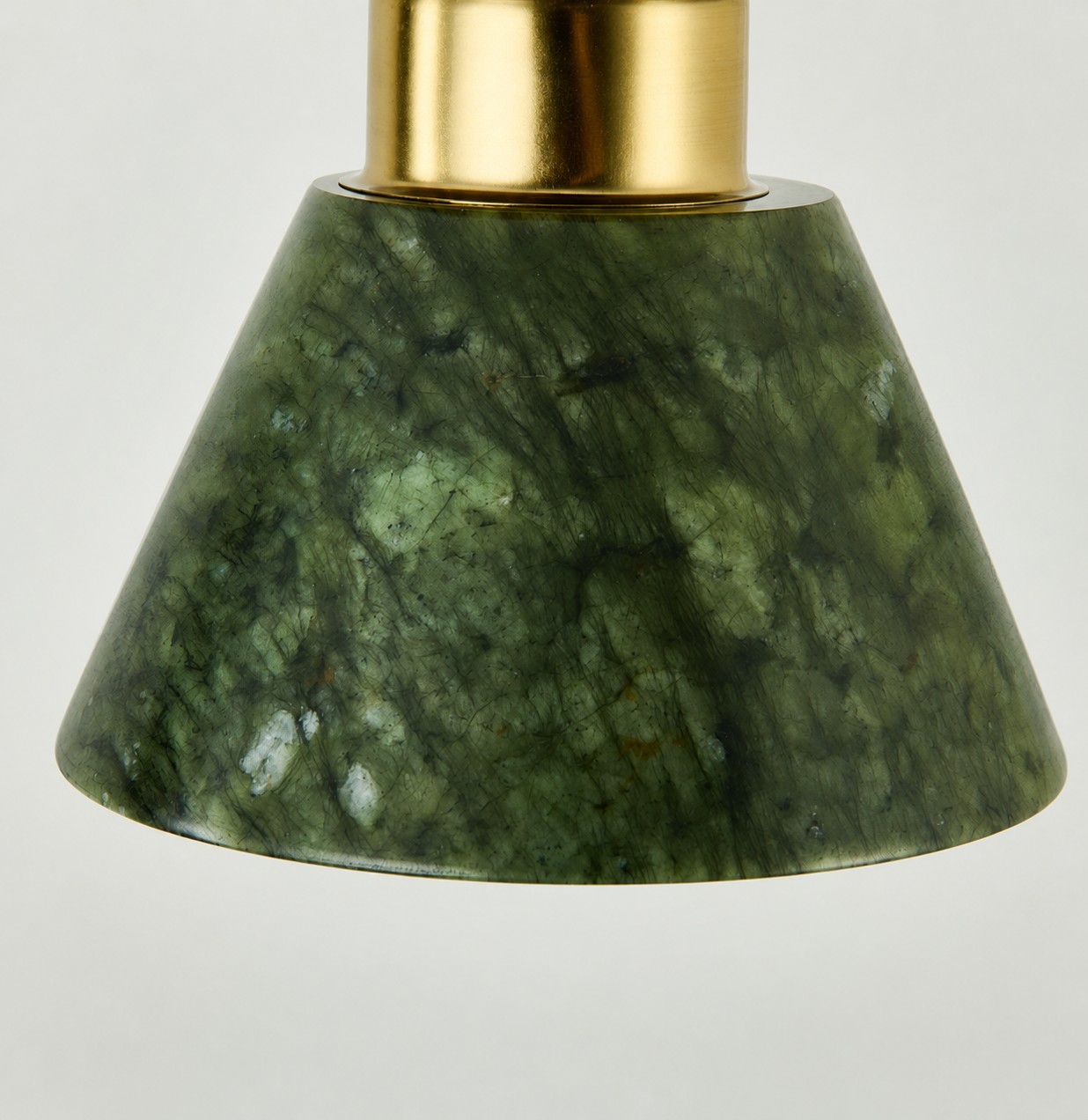 Primo piano della texture traslucida color verde giada e del bordo inferiore curvo.