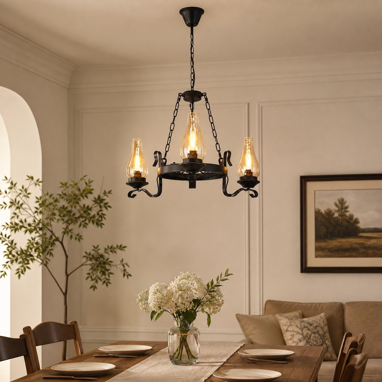 Een glazen kroonluchter met drie lampen boven een sfeervolle eettafel.