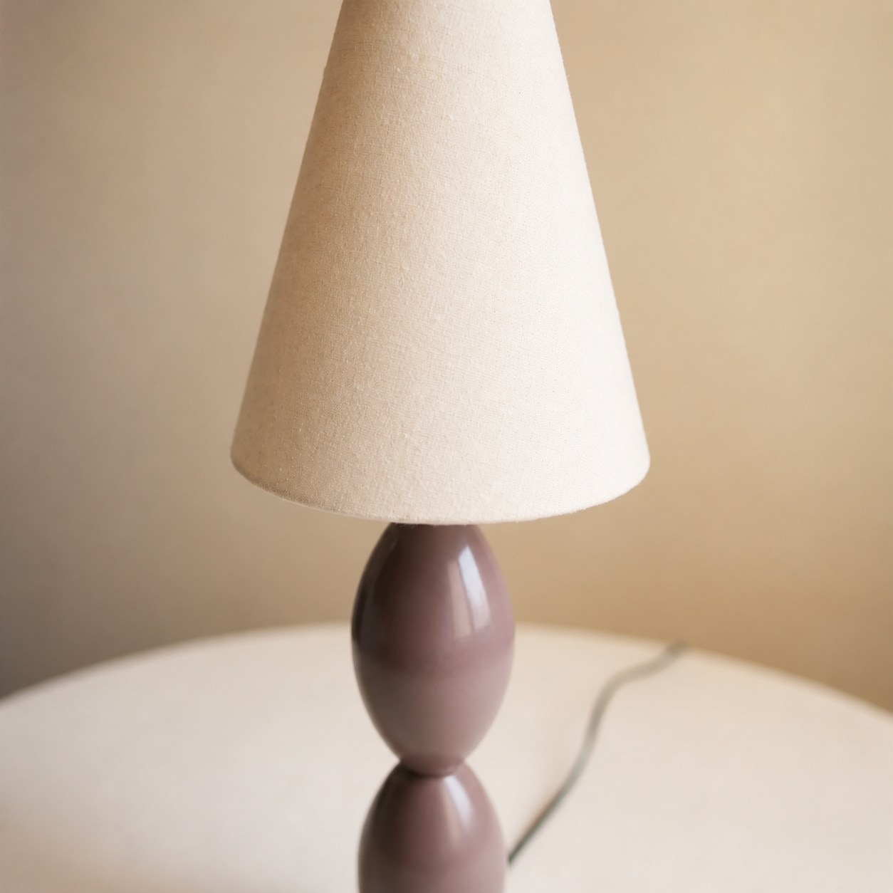 Close view of the textured fabric shade and taupe brown lamp body