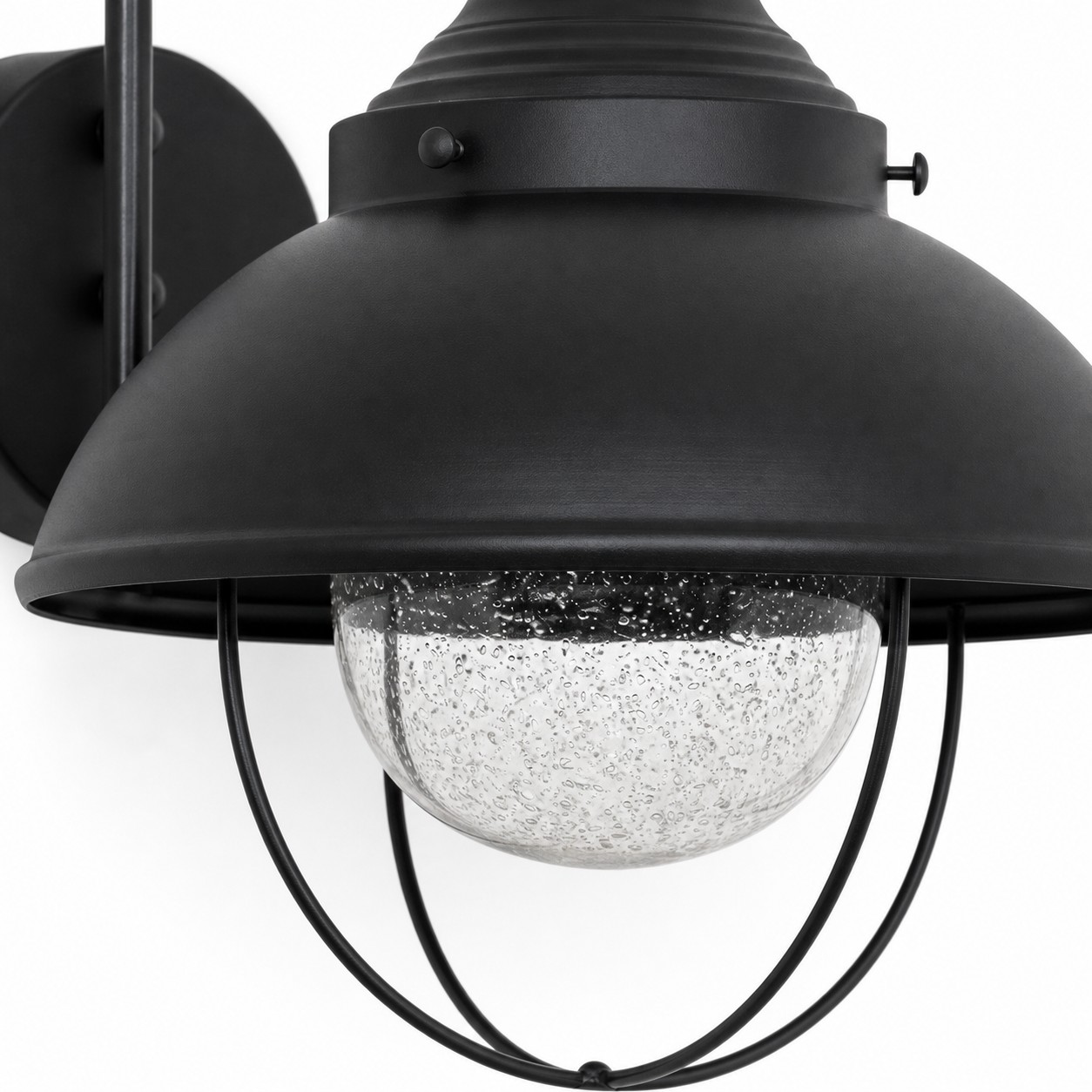 Globo in vetro soffiato sotto un paralume e una gabbia in metallo nero.