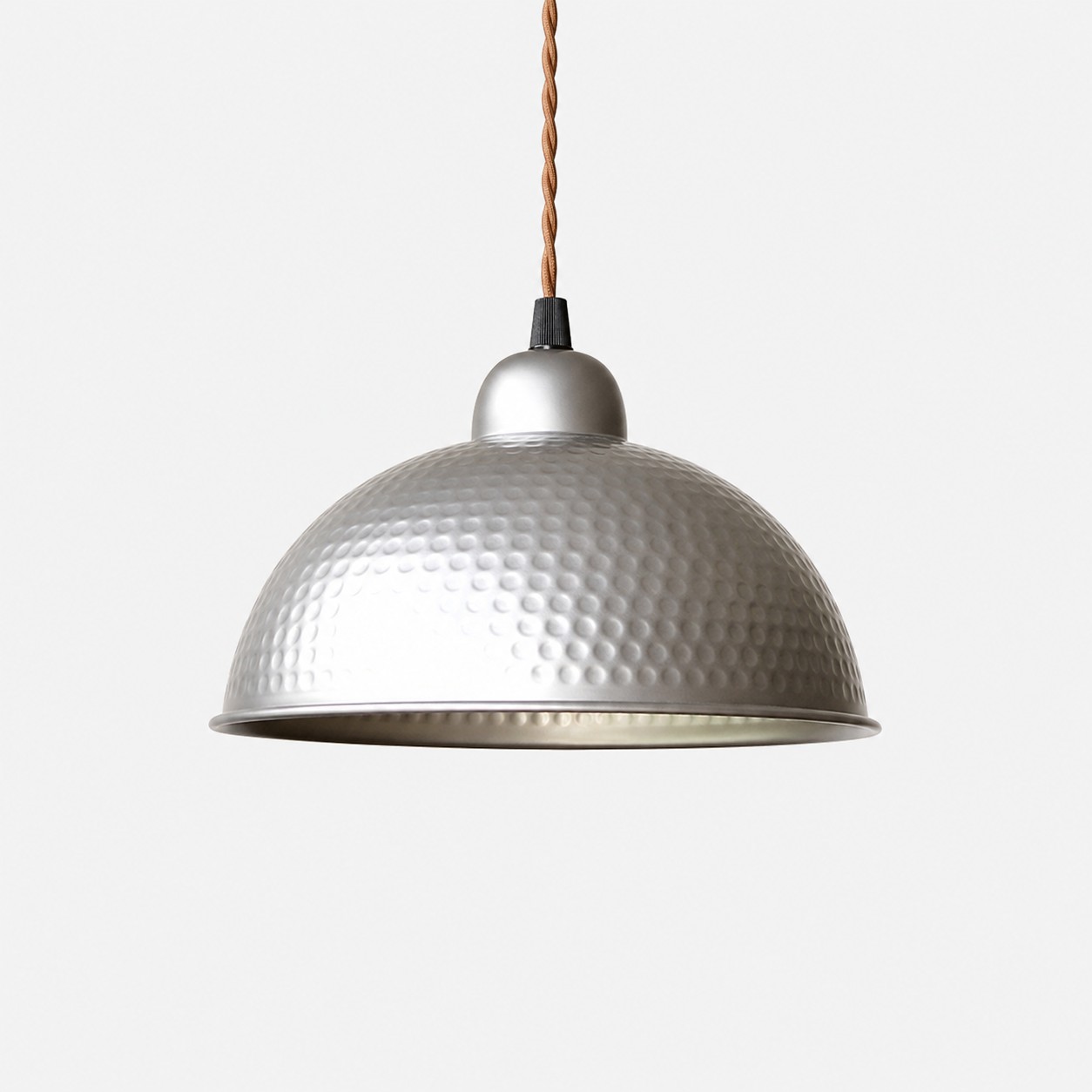 Lampada a sospensione con paralume a cupola martellato color argento.