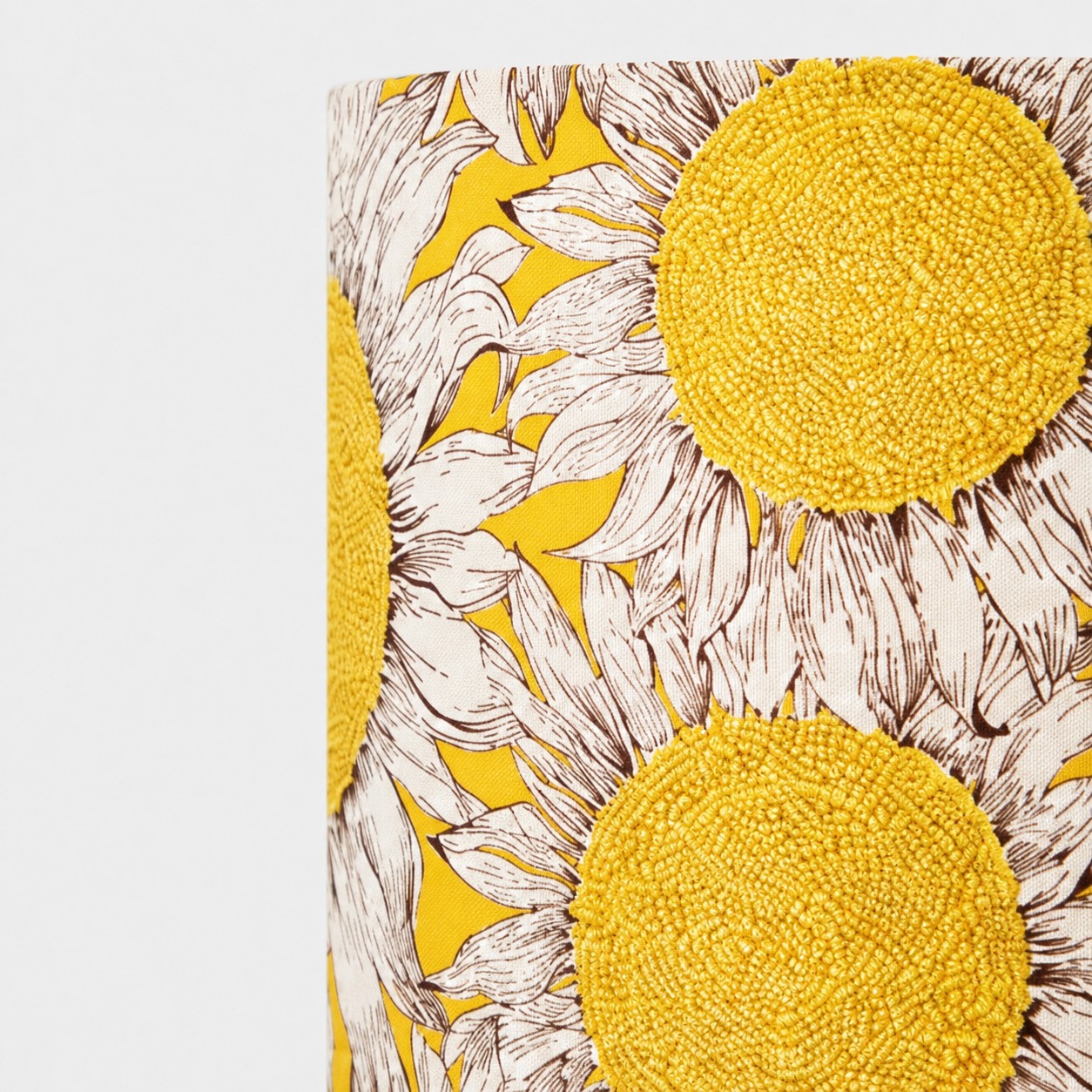 Tessuto a forma di girasole con ricami e dettagli intrecciati.