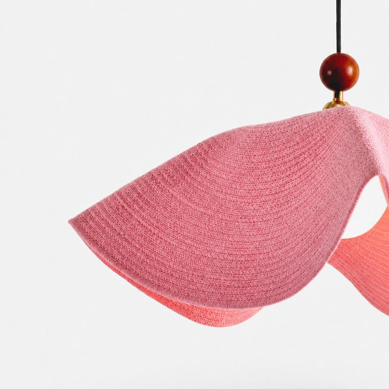 Close view of the pink woven shade and softly curved edge