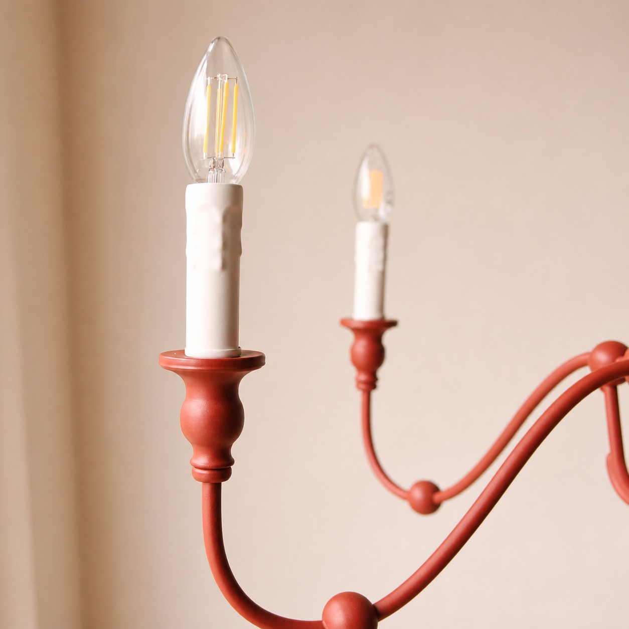Soquete de vela vermelho-vermelhão e detalhe de braço de ferro curvado