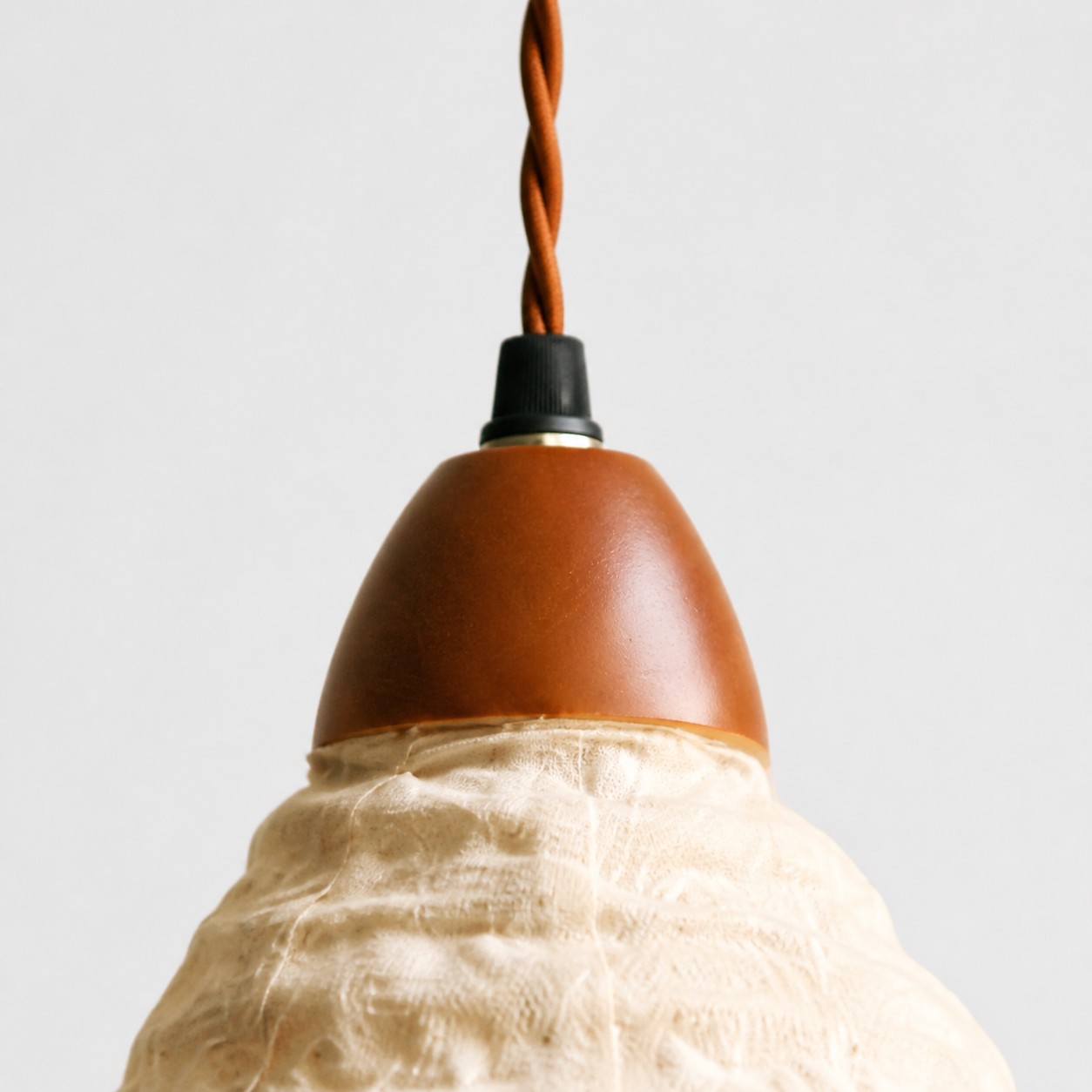 Wood lamp holder and braided cord connection above the fabric shade