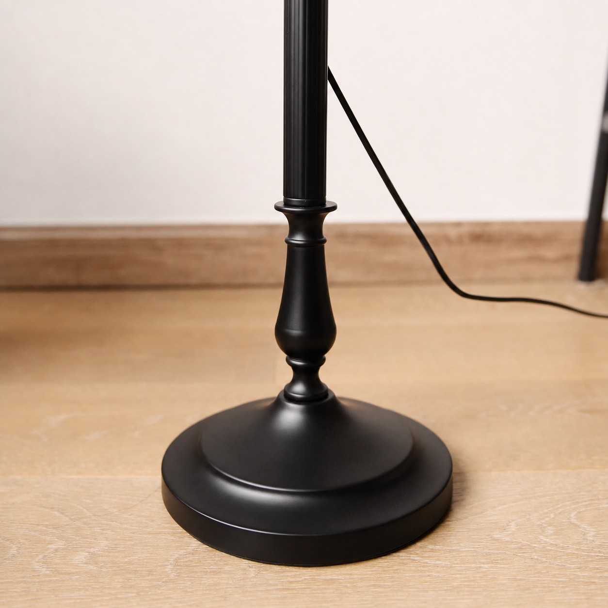 Black metal floor lamp base with foot switch cord detail