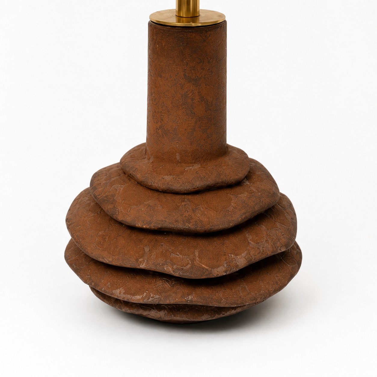 Dettaglio della base a più livelli in ceramica testurizzata della lampada da tavolo.