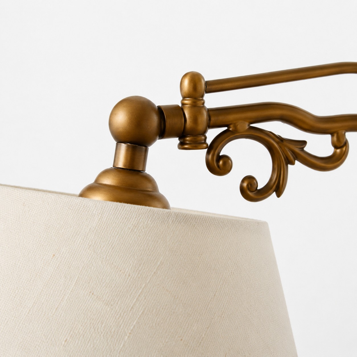 Close view of the antique brass-tone scrollwork and fabric shade