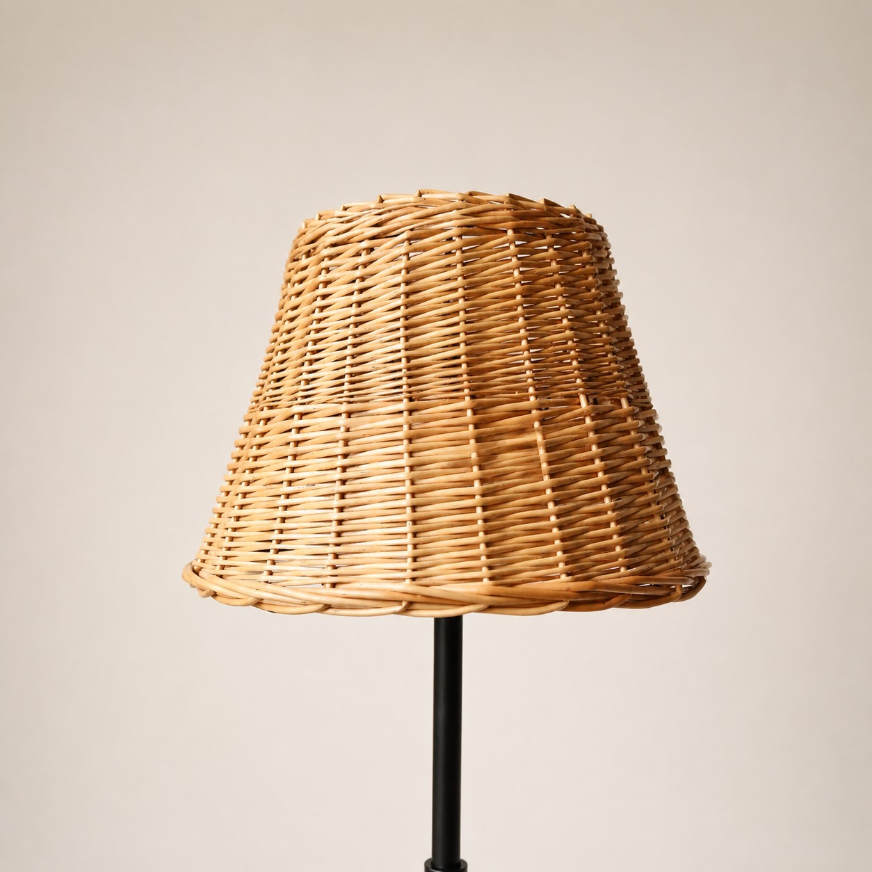 Natural woven shade on a slim black floor lamp stand