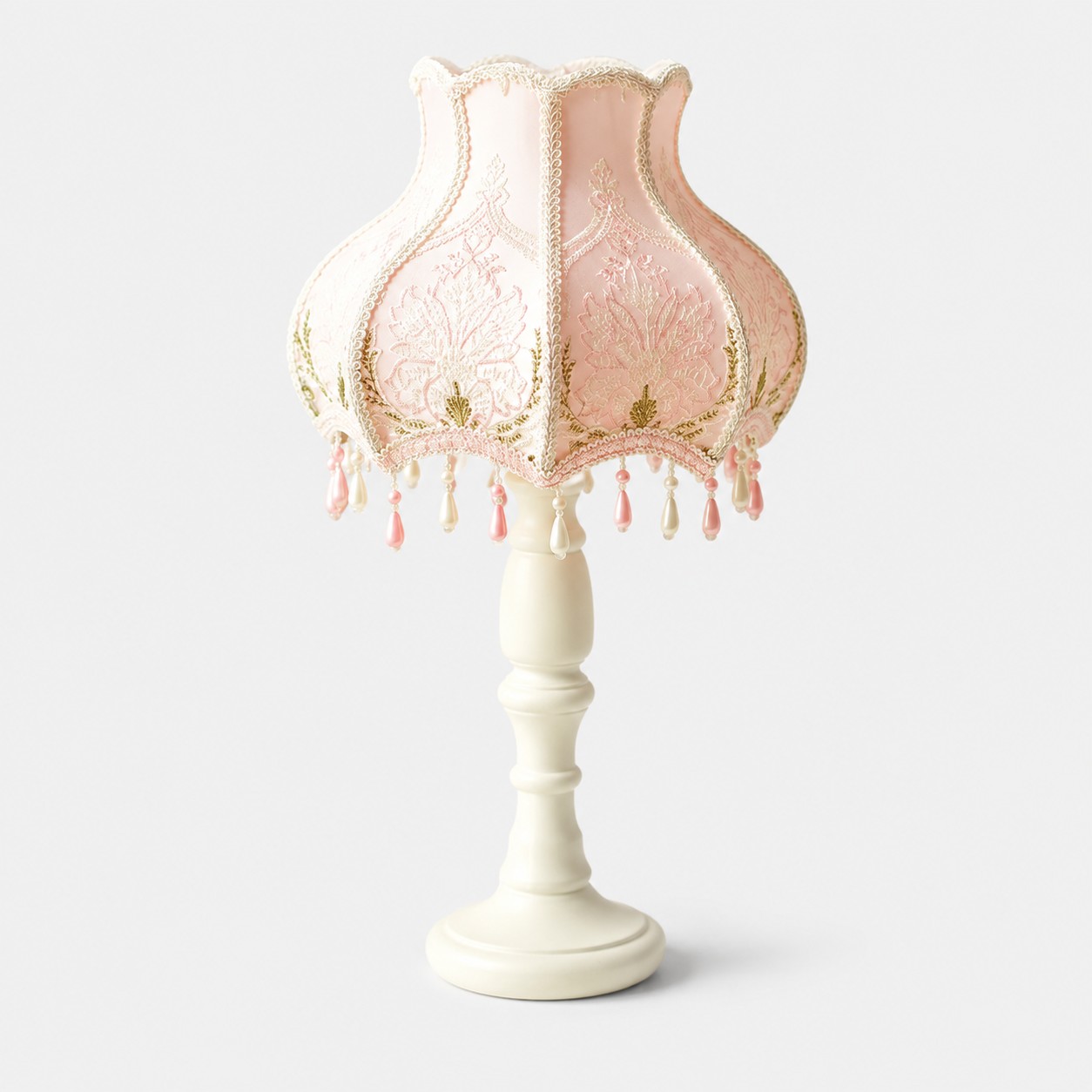 Rosa pärlspetsbordslampa med fransar mot ljus bakgrund