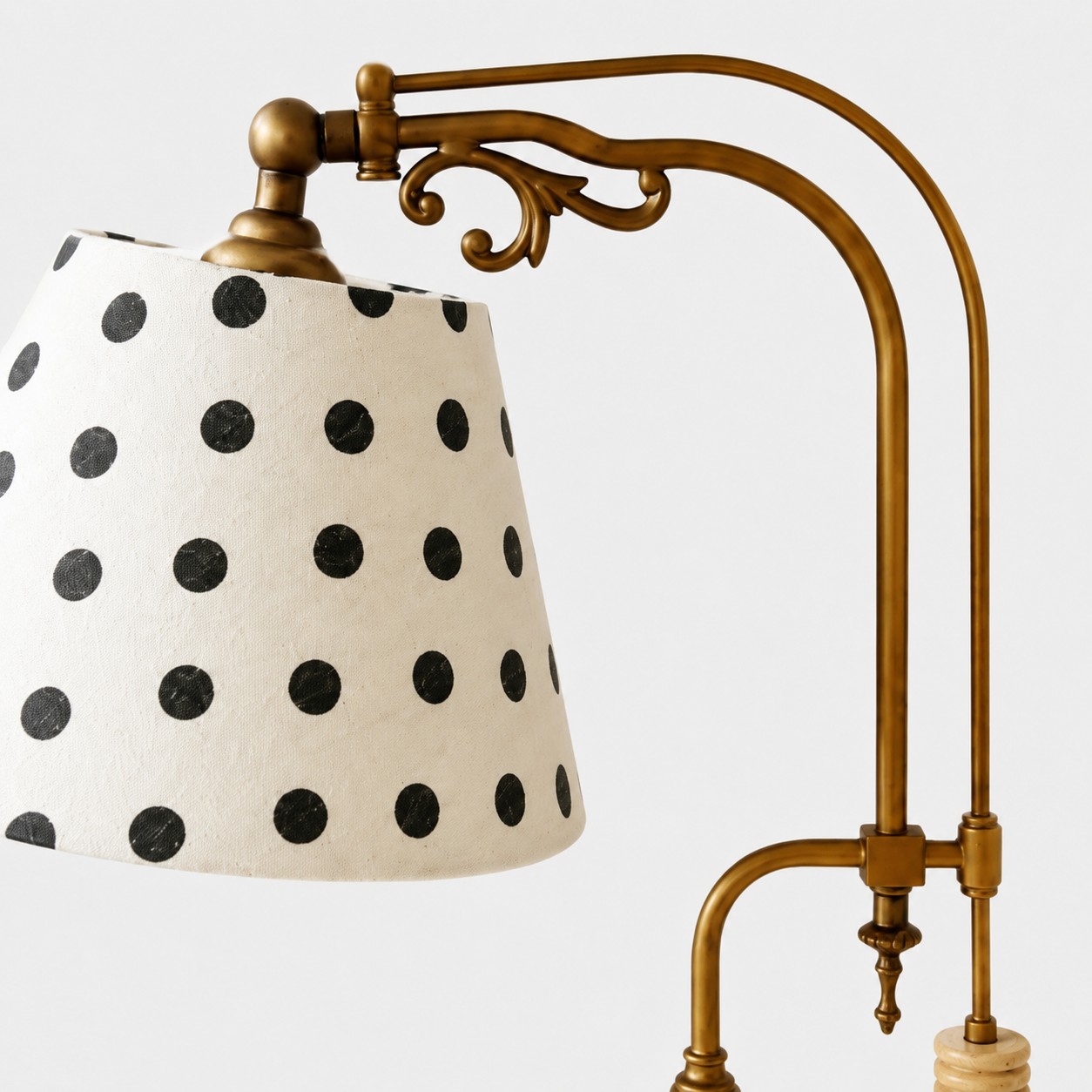 Close view of the polka dot fabric shade and curved metal frame
