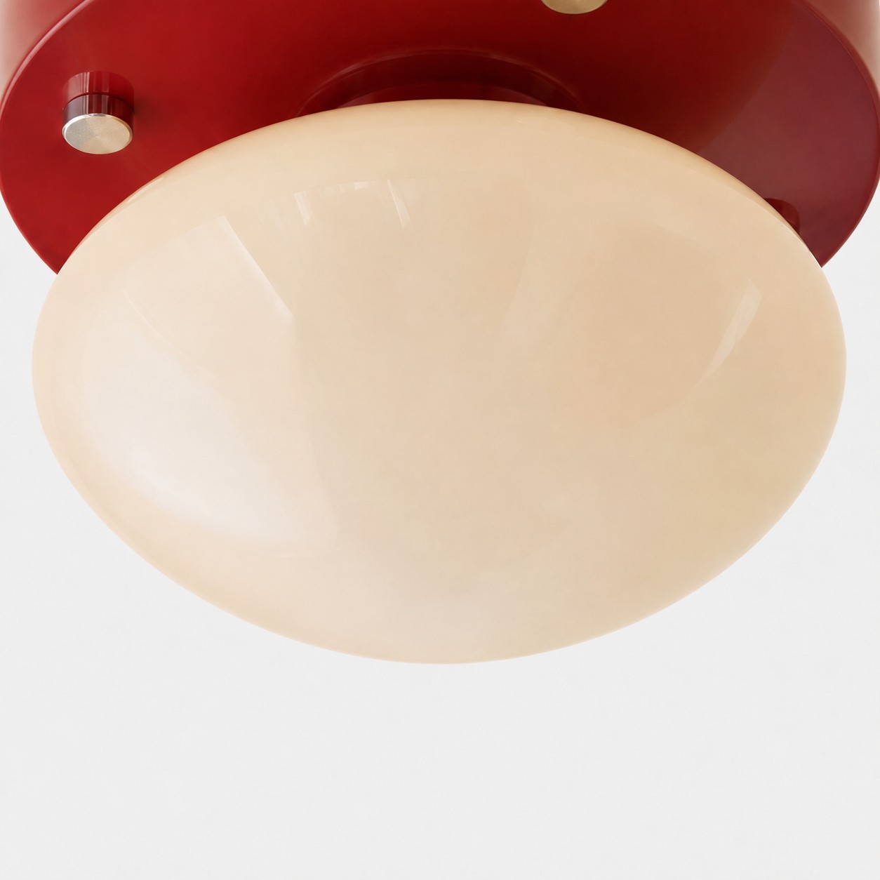 Nahaufnahme eines cremefarbenen Glasdiffusors an einer roten LED-Deckenleuchte