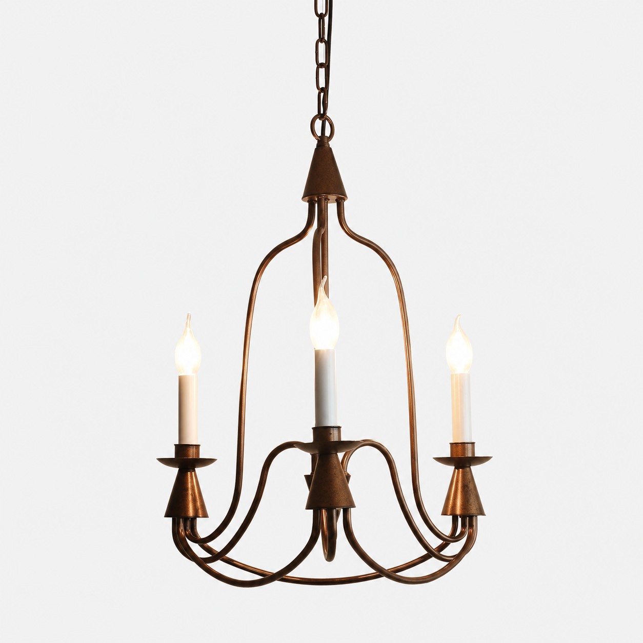 Lámpara de araña antigua de bronce con tres luces y candelabro de hierro.