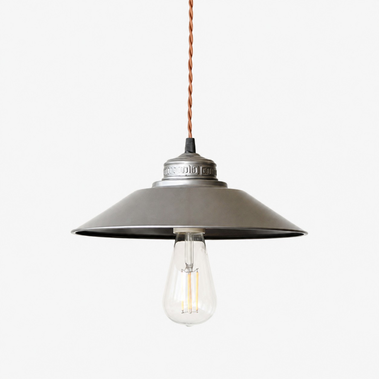Lampada a sospensione con paralume a disco scanalato color argento.